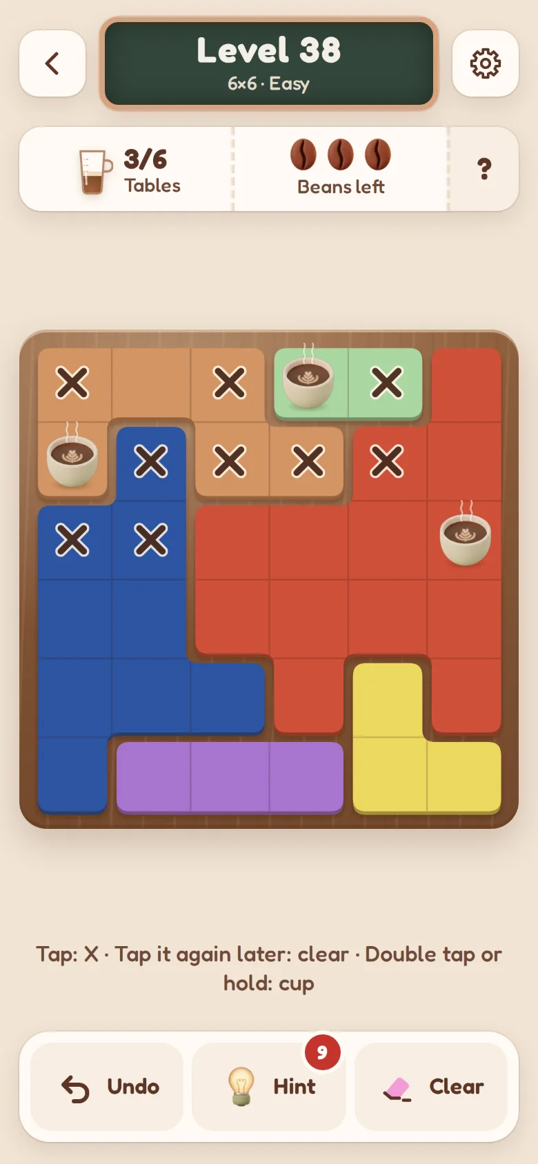 A level in progress: three cups on painted tables on a wooden tray, with X marks around them.